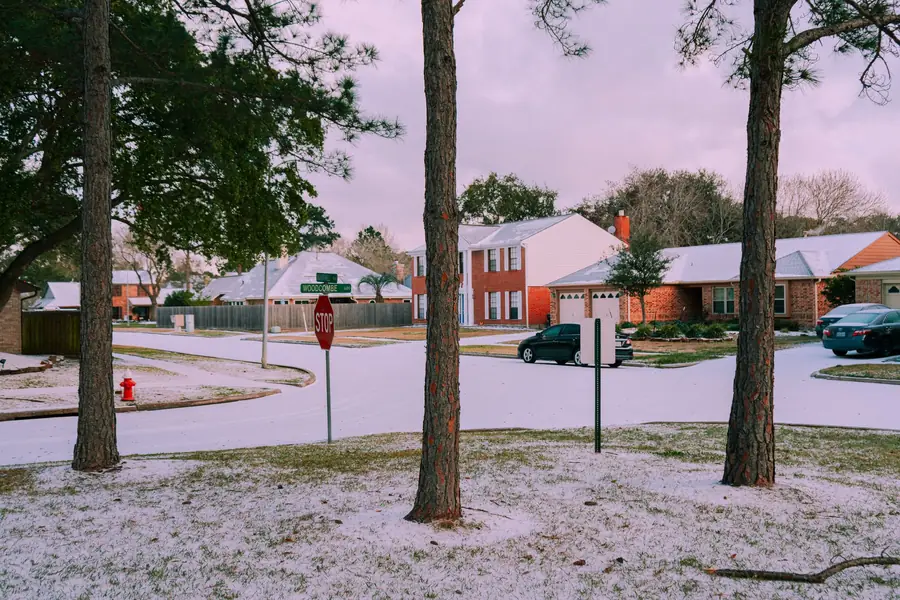 Snow and ice covering a street of brick houses in North Texas