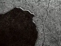 Water spreading across cracked concrete